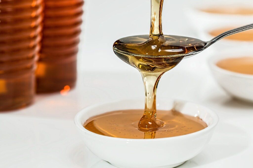 pouring honey on spoon