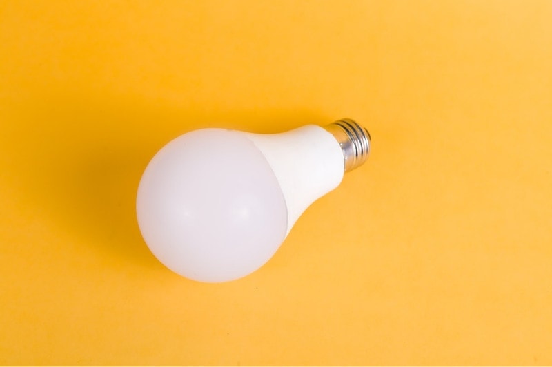 white light bulb on a yellow surface