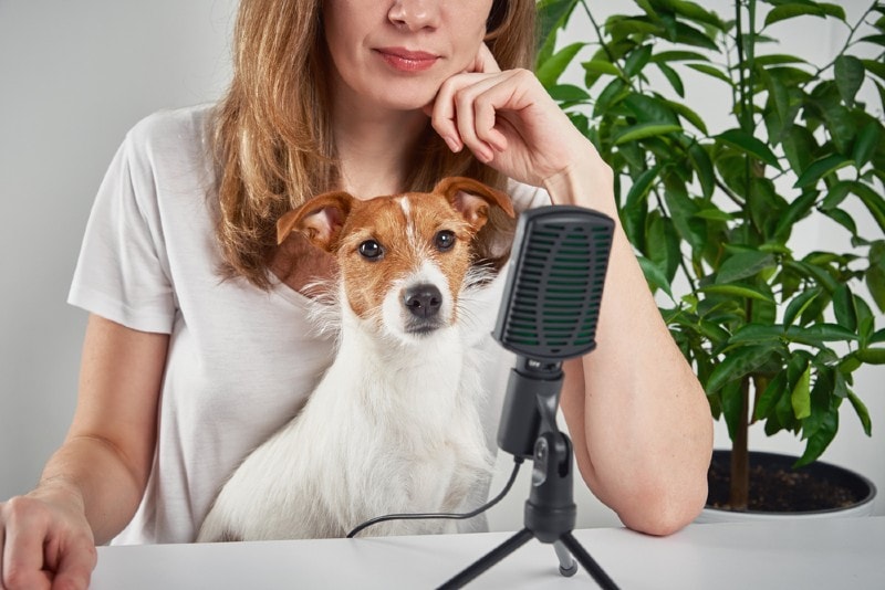 woman recording podcast with her pet dog